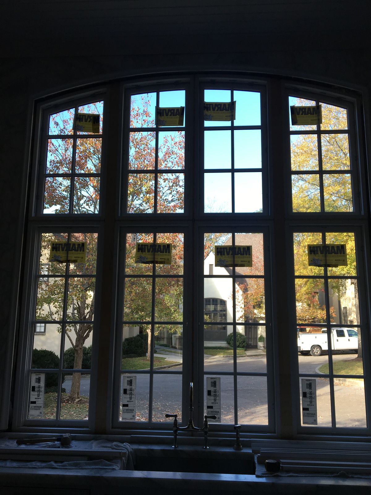 Large arched Marvin window installed above a kitchen sink