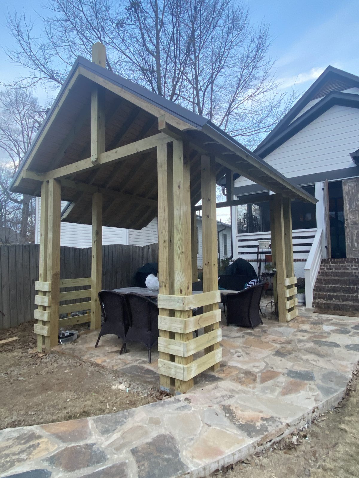 Custom-built backyard pergola over a flagstone patio