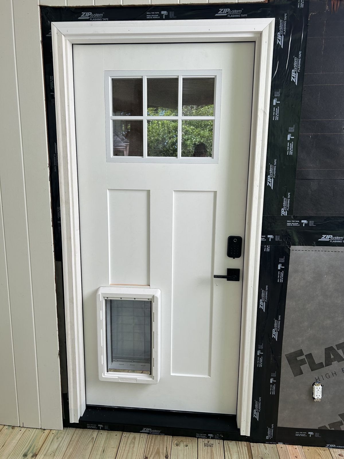 Craftsman entry door with pet door installed with properly flashed and taped opening