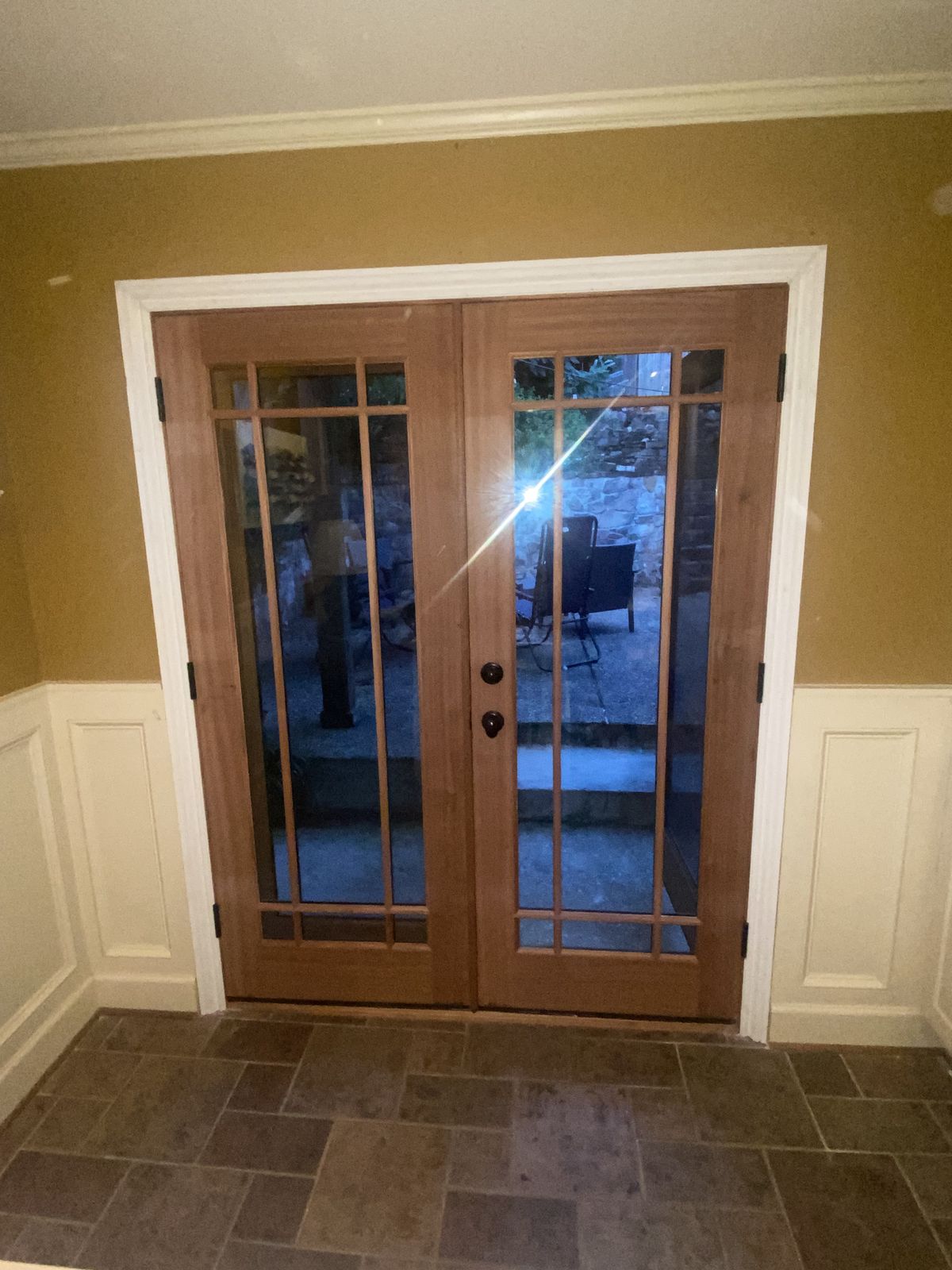 Mahogany French doors with divided lites opening onto a patio